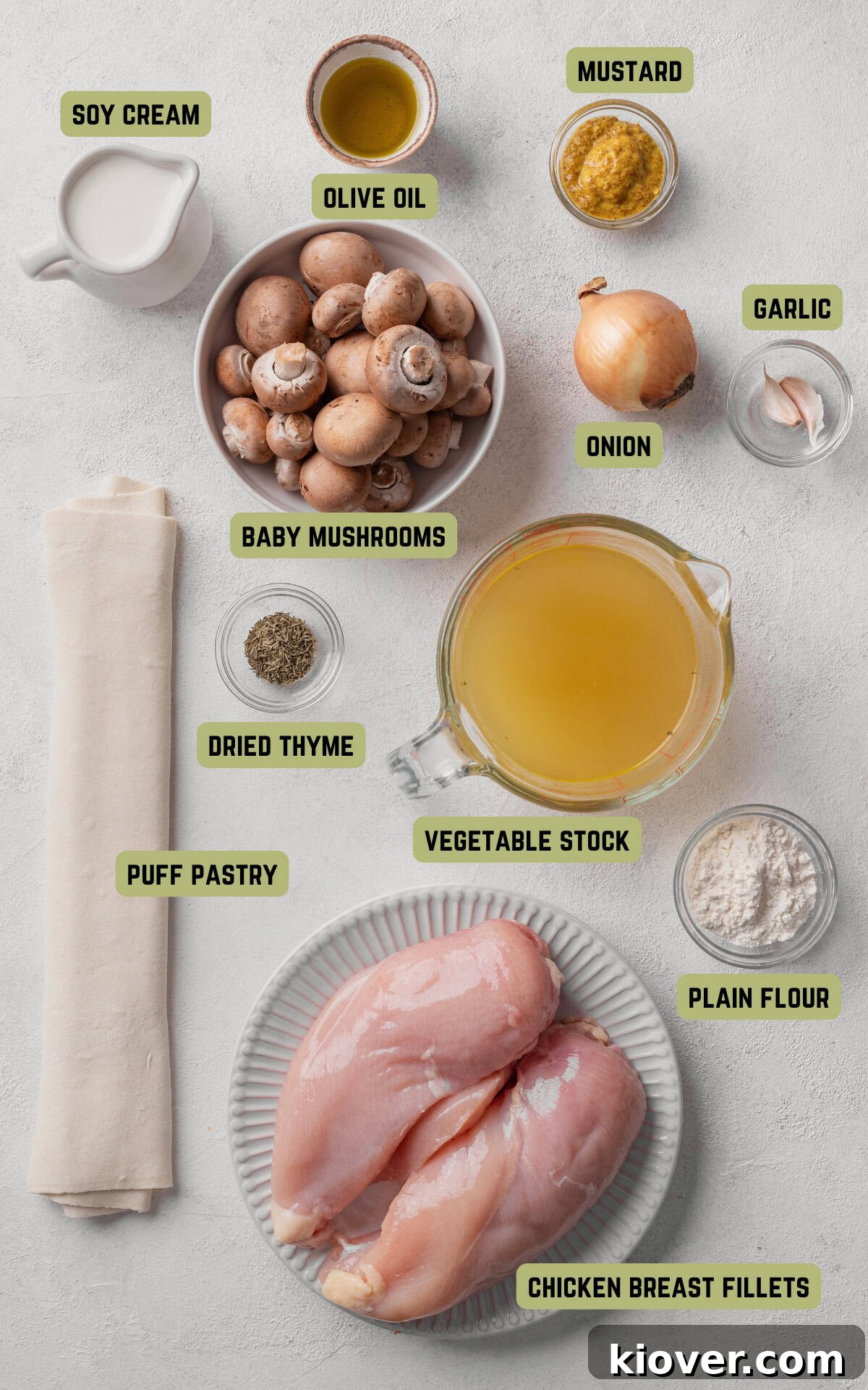 Assorted ingredients laid out for making Chicken and Mushroom Pie, including fresh chicken, mushrooms, onions, garlic, and herbs.