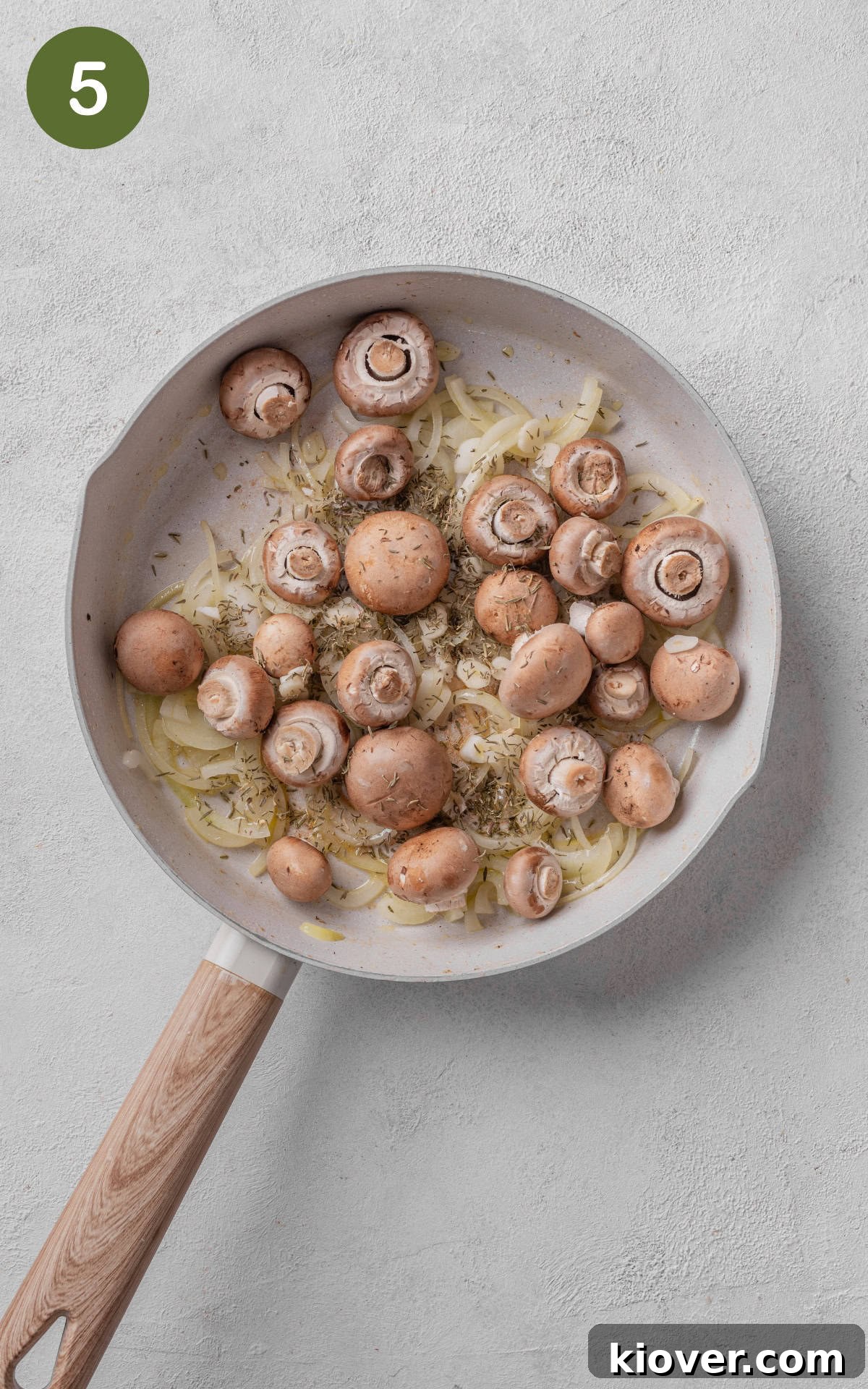 Mushrooms and dried thyme cooking in a skillet, releasing their juices.