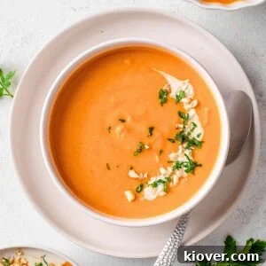 Sweet potato soup garnished with fresh parsley and chopped cashews, ready to serve.
