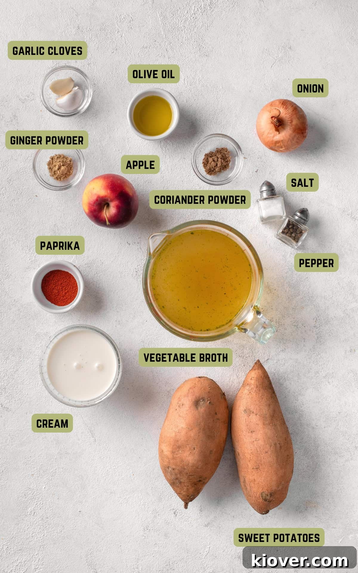 Spiced Sweet Potato Warmth 3 A vibrant selection of ingredients laid out on a wooden board, including sweet potatoes, an apple, onion, garlic, and various spices for making sweet potato soup.
