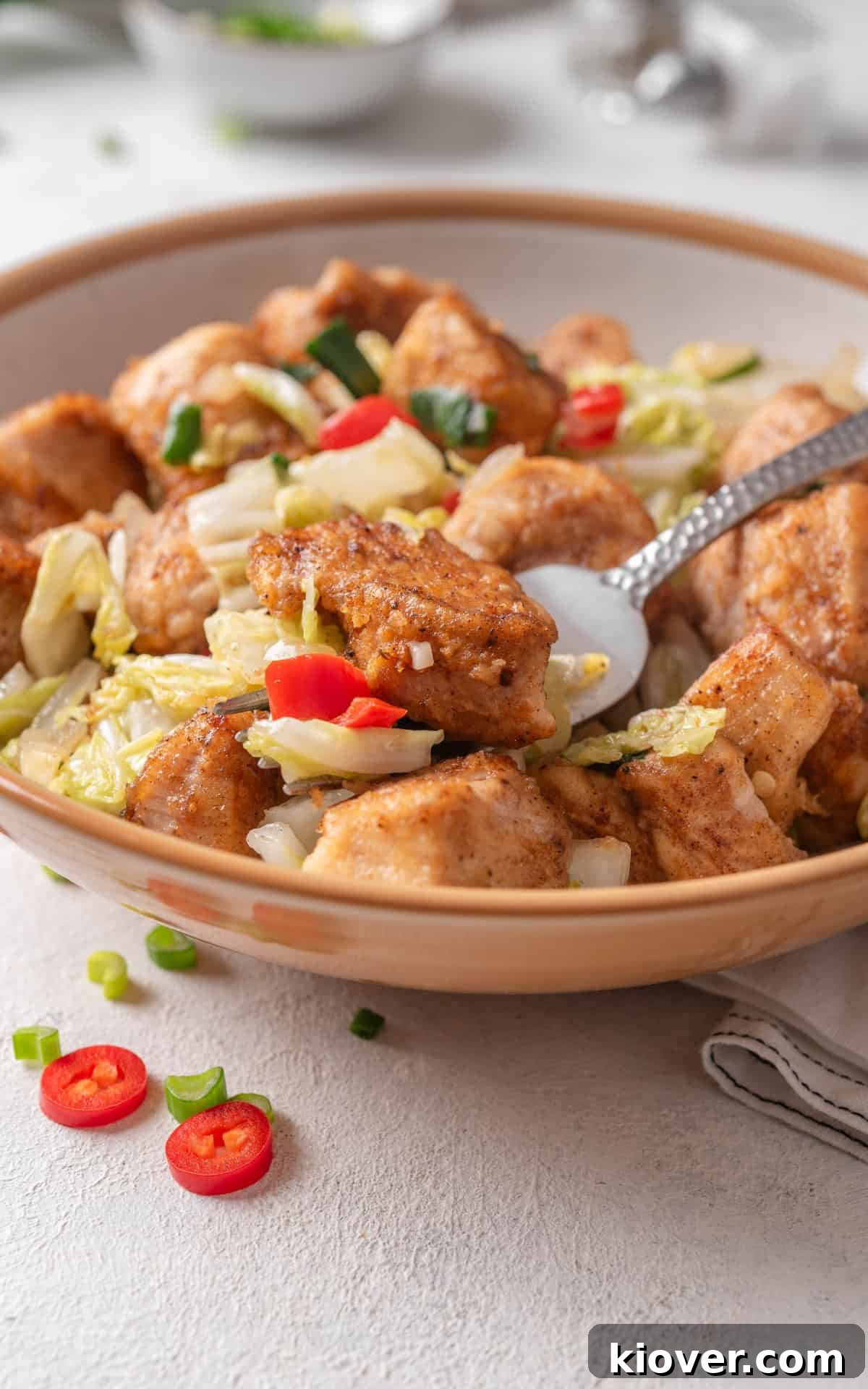 A close-up shot of a vibrant and aromatic Salt and Pepper Chicken Chinese Stir Fry, glistening with sauce and topped with fresh herbs.