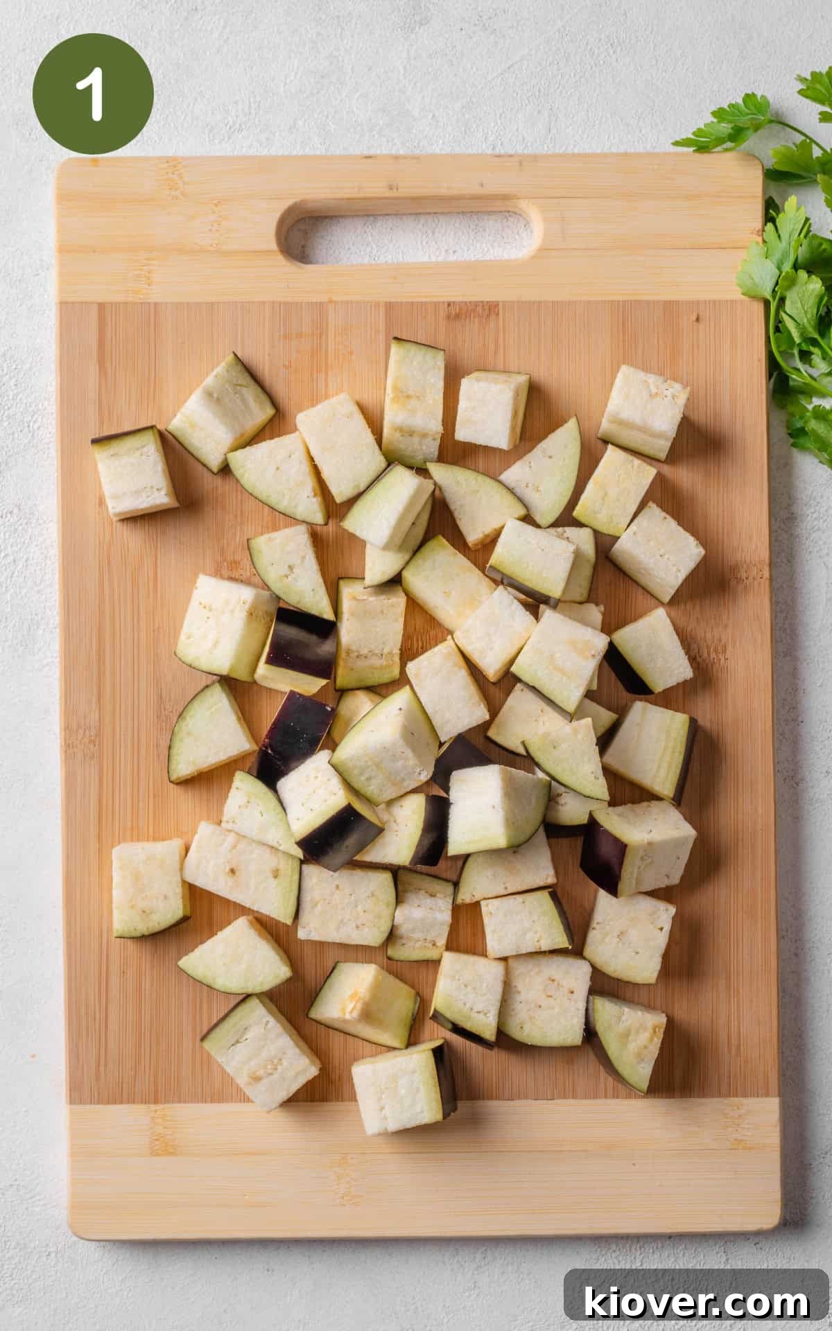 Aubergine cubes on a cutting board, ready for roasting.