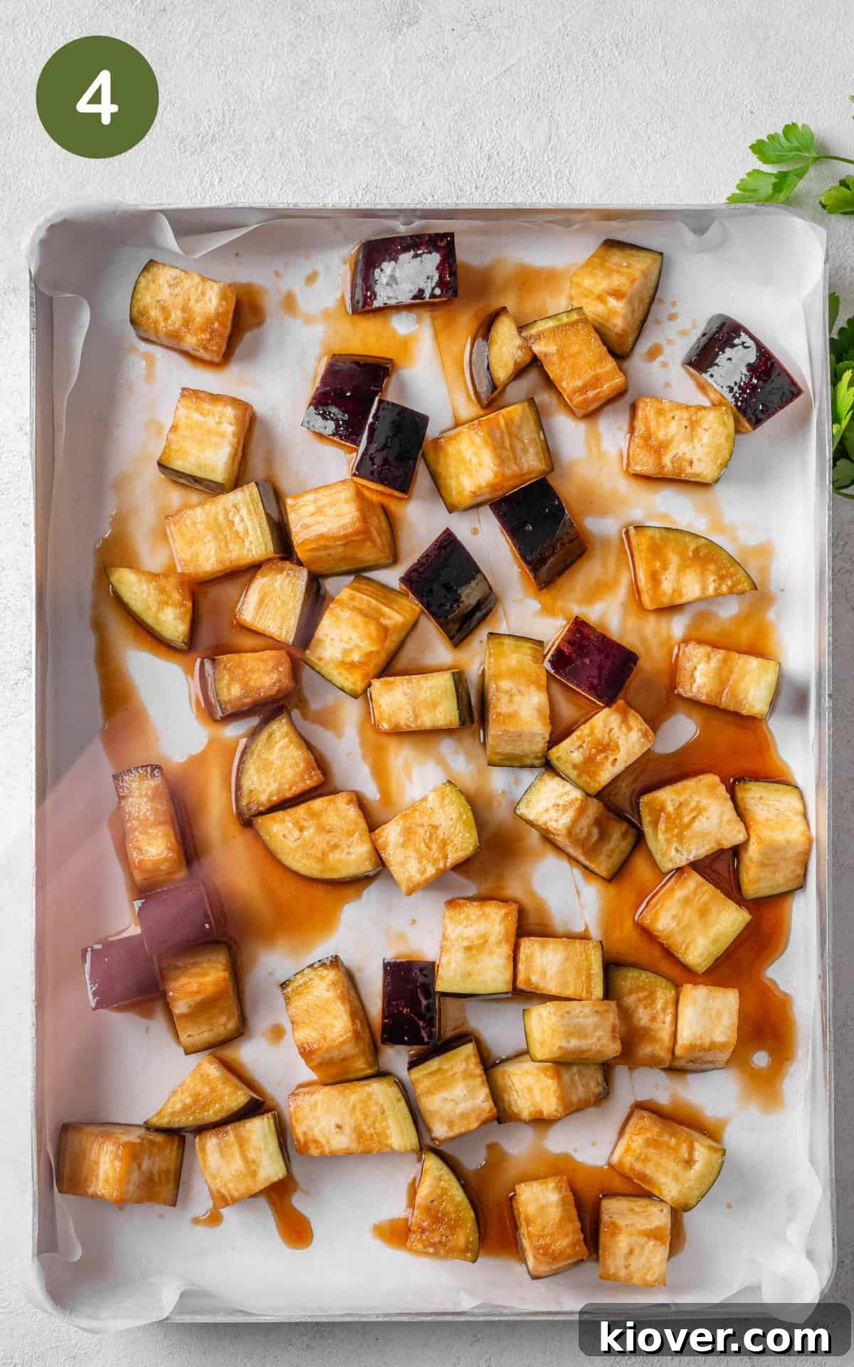Aubergine cubes spread in a single layer on a baking tray.