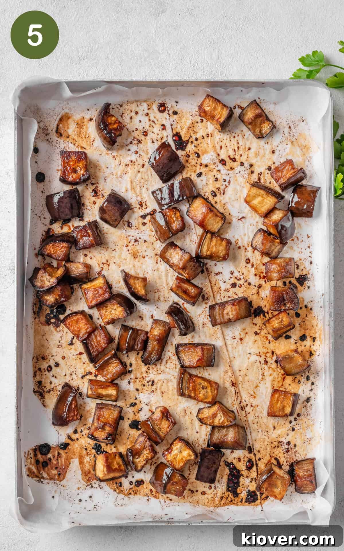 Caramelized aubergine cubes on a baking tray after roasting.