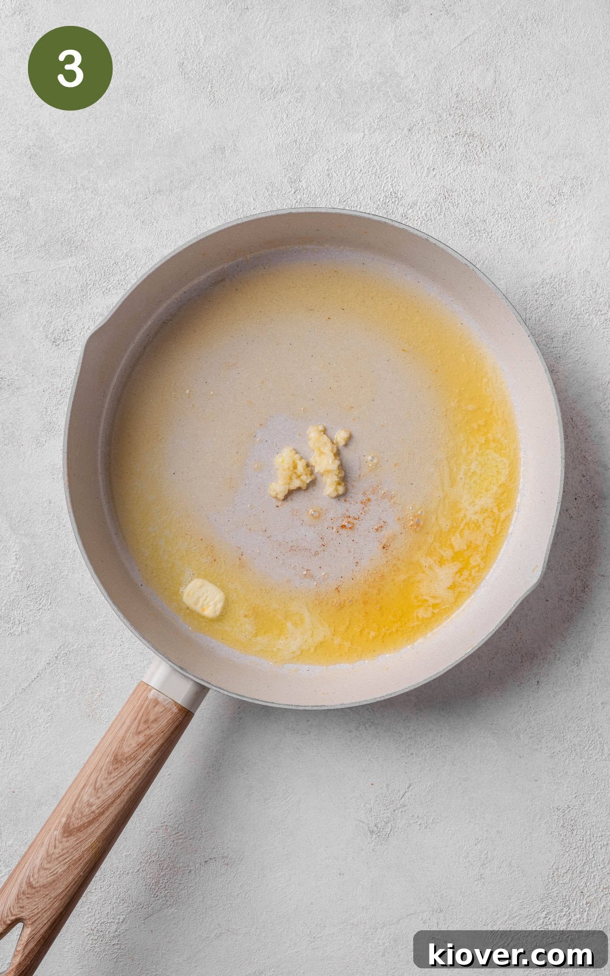 Melted butter and minced garlic simmering in a skillet, filling the kitchen with aroma.
