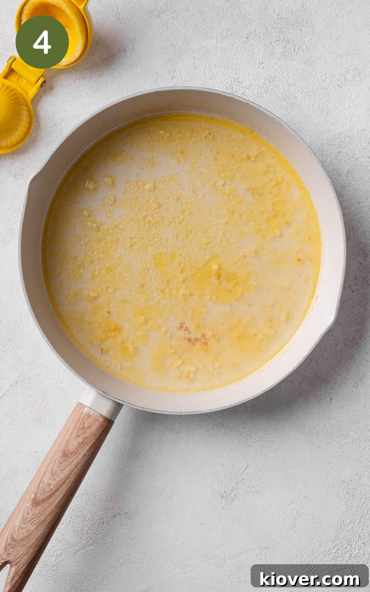 Vegetable stock and lemon juice added to the garlic butter in a skillet, simmering to create a creamy sauce.