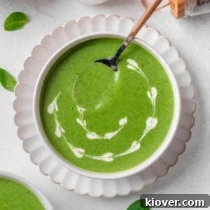 Velvety Spinach Soup 10 A vibrant bowl of creamy spinach soup, garnished with a swirl of plant-based cream, ready to be enjoyed.
