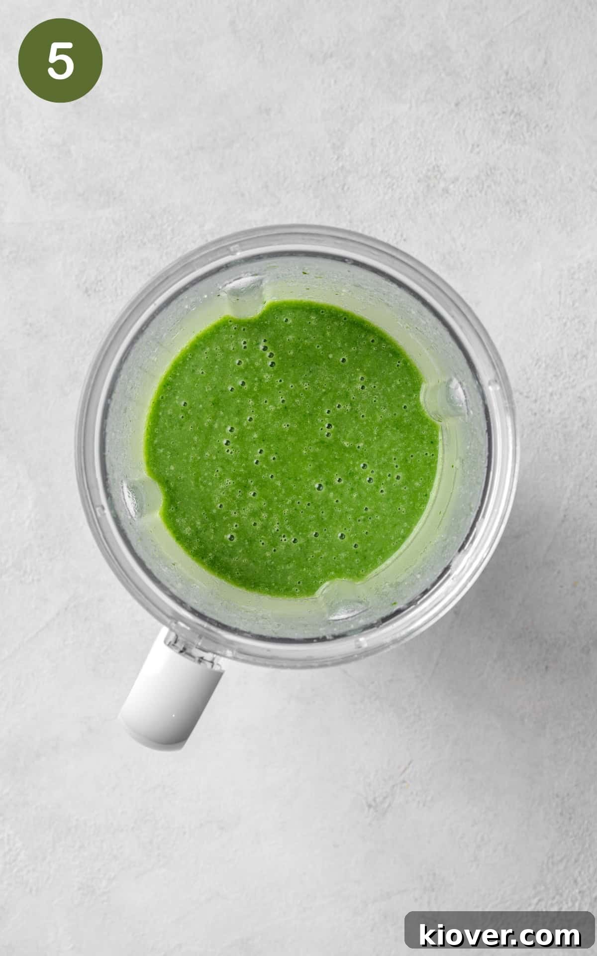 Velvety Spinach Soup 8 Creamy spinach soup blending smoothly in a high-speed blender, creating a vibrant green color.