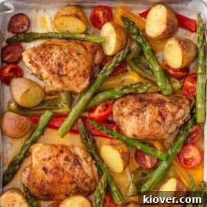Roasted chicken thighs with vegetables on a pan.