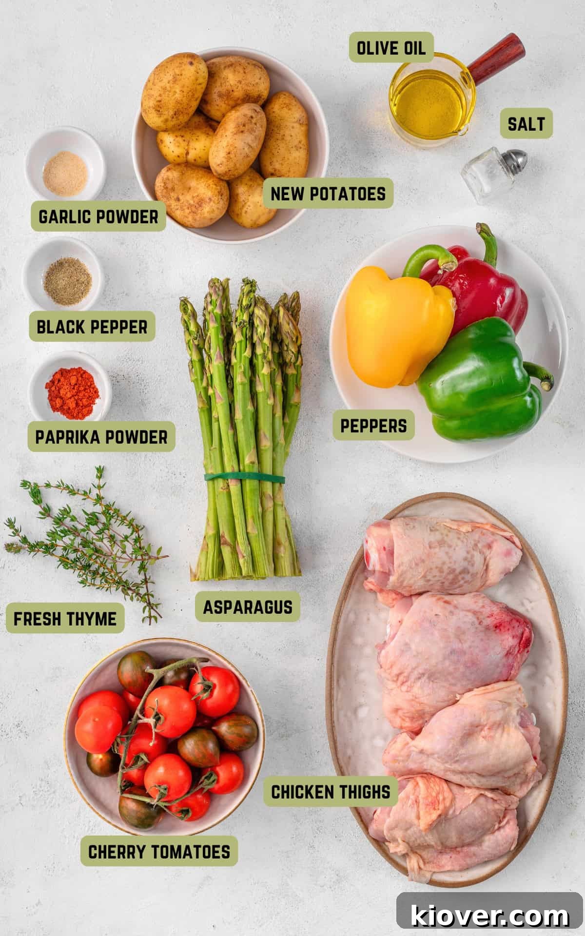 Assorted fresh ingredients for chicken thigh tray bake, including chicken, potatoes, bell peppers, and herbs.