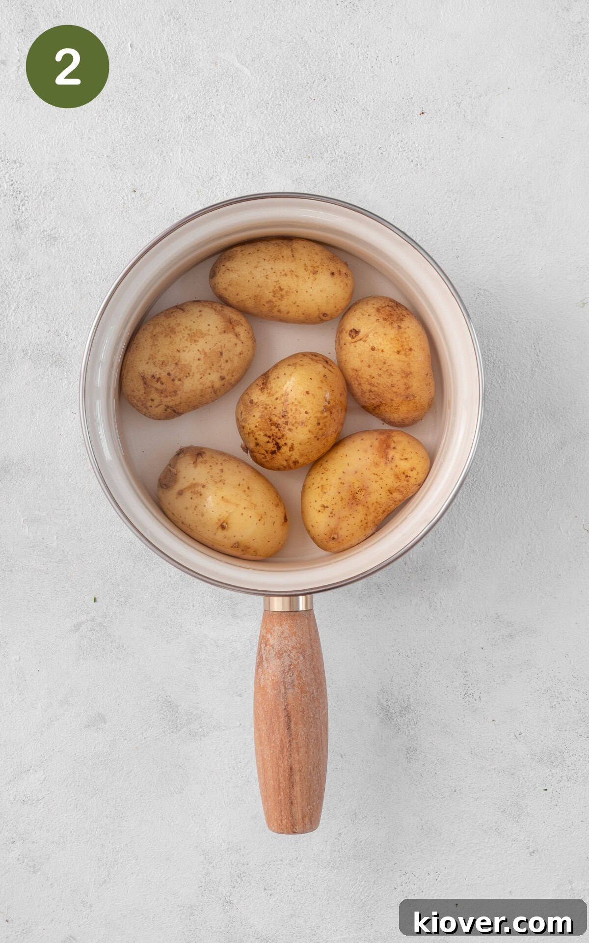 New potatoes boiling in a saucepan on the stove.