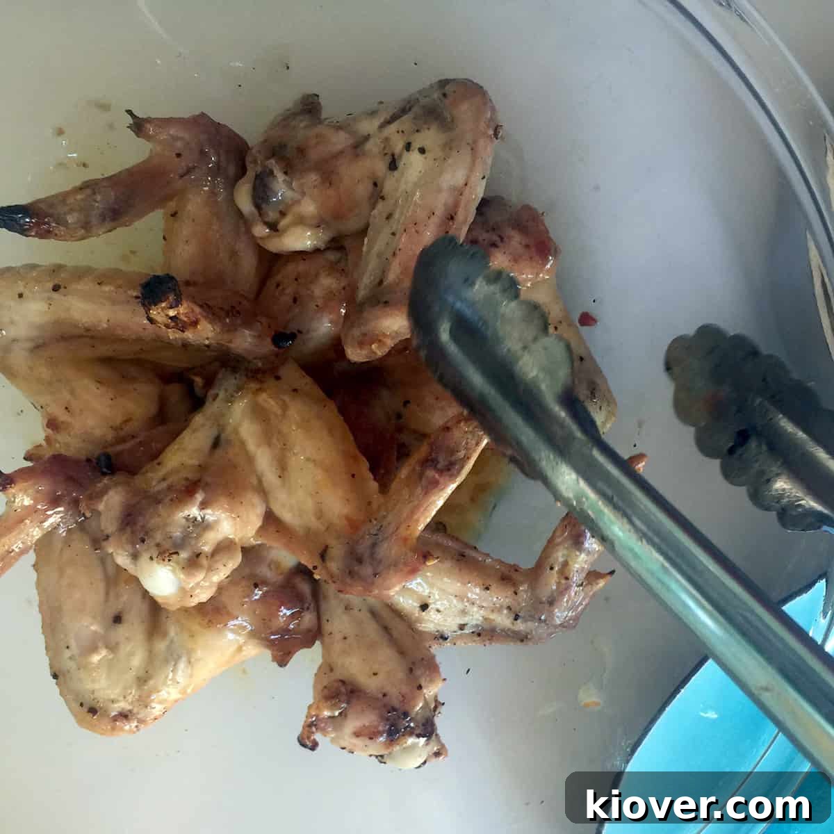Tossing Wings Cooked chicken wings being generously tossed in a bowl with the vibrant tequila lime sauce, ensuring every piece is coated.