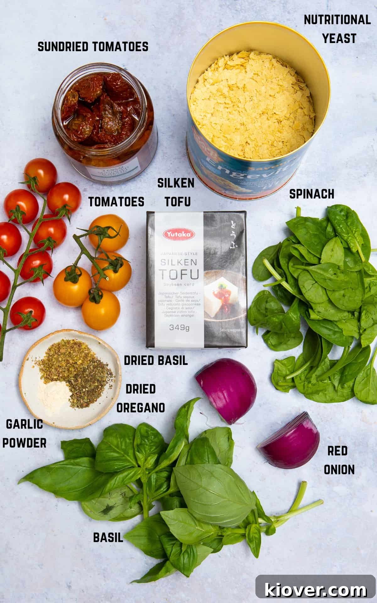 A vibrant selection of ingredients for the vegan quiche filling, beautifully arranged on a grey marble background.