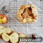 Overhead shot of our apple crostata recipe on a wire tray. There are several cut apples and a small container with cinnamon on it as well.