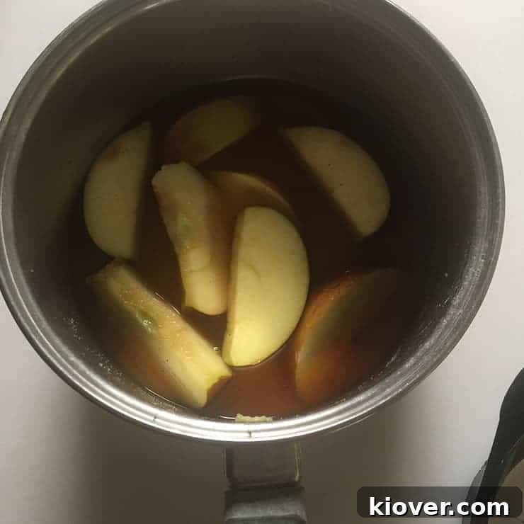 Simmering Apple Brandy liquid in saucepan