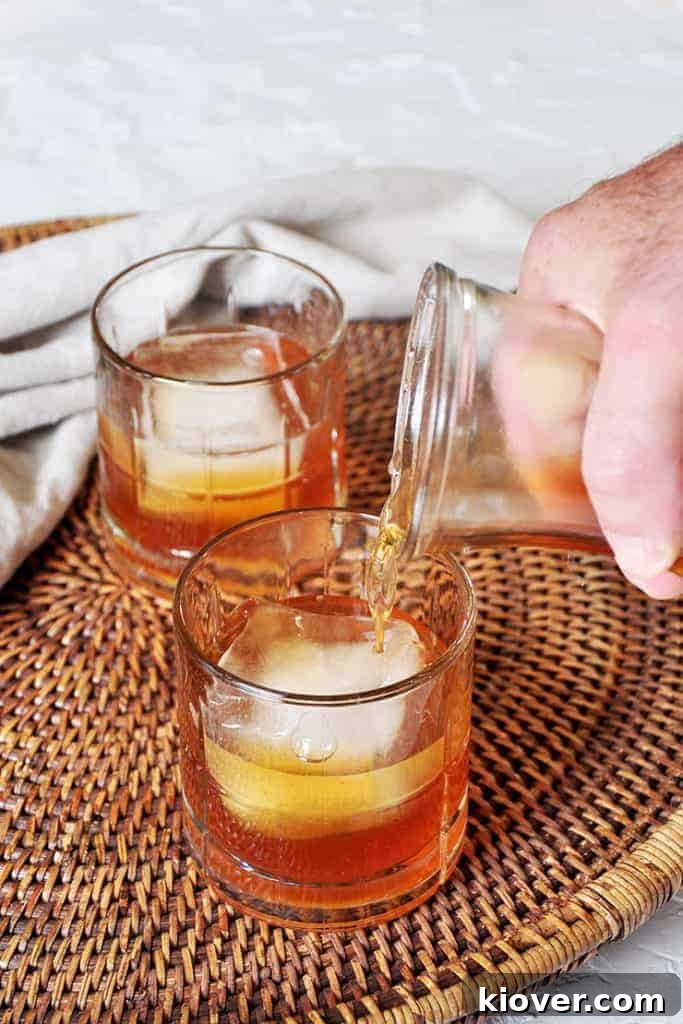 Pouring apple brandy into a glass from a carafe