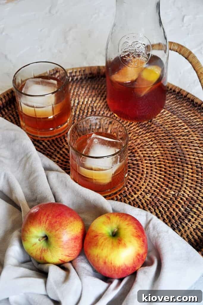 Carafe of apple brandy on a platter. Two Braeburn apples showing