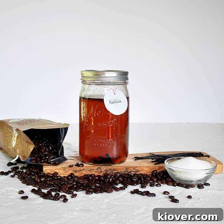 A quart jar of homemade DIY Kahlua resting on a rustic wooden platform, adorned with scattered coffee beans and sugar. The scene evokes a sense of natural, handcrafted goodness.