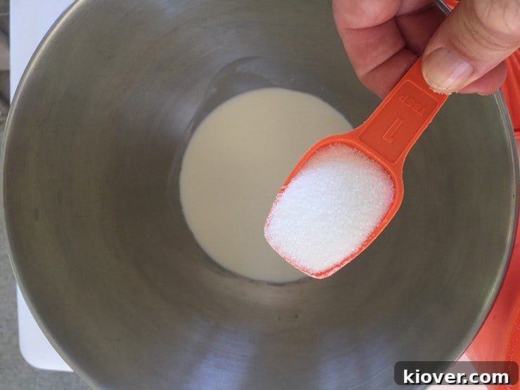Pouring sugar into cold heavy cream.