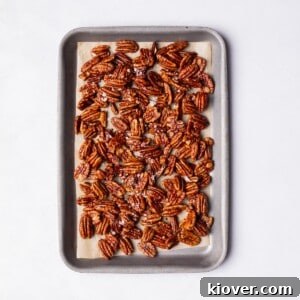 Sweet and Salty Candied Pecans spread on a baking tray, glistening and ready for snacking or gifting during the holidays.