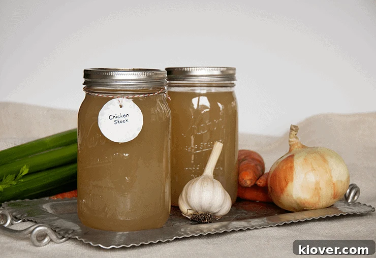 Two quarts of homemade chicken stock on a tin platter.
