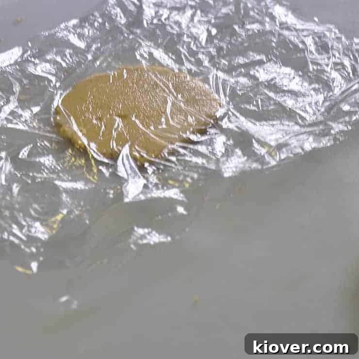 A flattened tortilla between two sheets of plastic wrap.