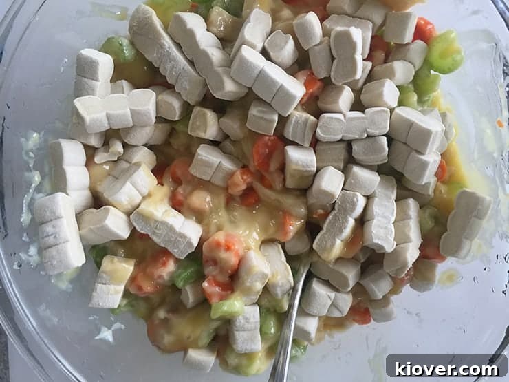 All the casserole ingredients mixed together in a large glass bowl, ready for baking.