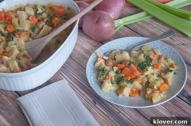 A serving of the Knöpfle-style chicken and dumpling casserole on a plate, next to the full casserole dish.