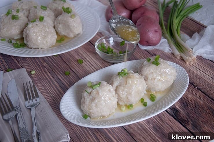 Melted butter being generously poured over a serving of Klubb dumplings on a plate, highlighting the simple yet delicious presentation.