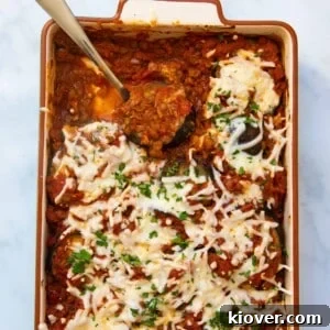 Divine Eggplant Casserole 9 A close-up of the delicious aubergine bake being served with a silver spoon, highlighting its warm, comforting appeal.
