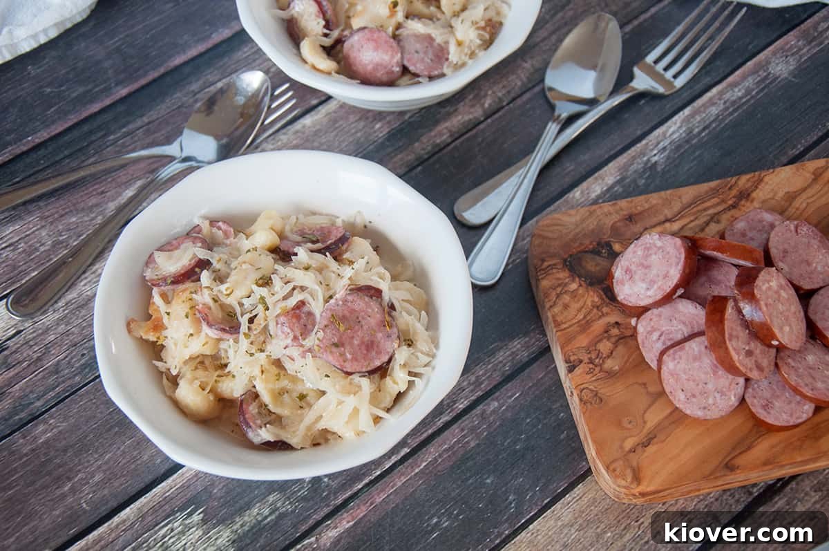 Sauerkraut and sausage in a white bowl, showing the creamy texture and hearty ingredients.