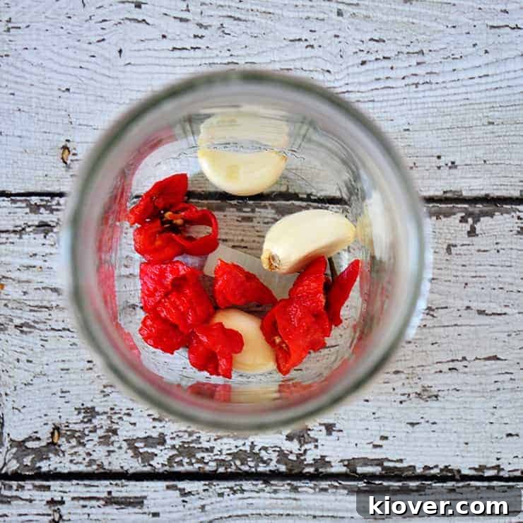 Spice and Garlic Fresh Carolina Reaper peppers and garlic cloves settling in the pickling jar