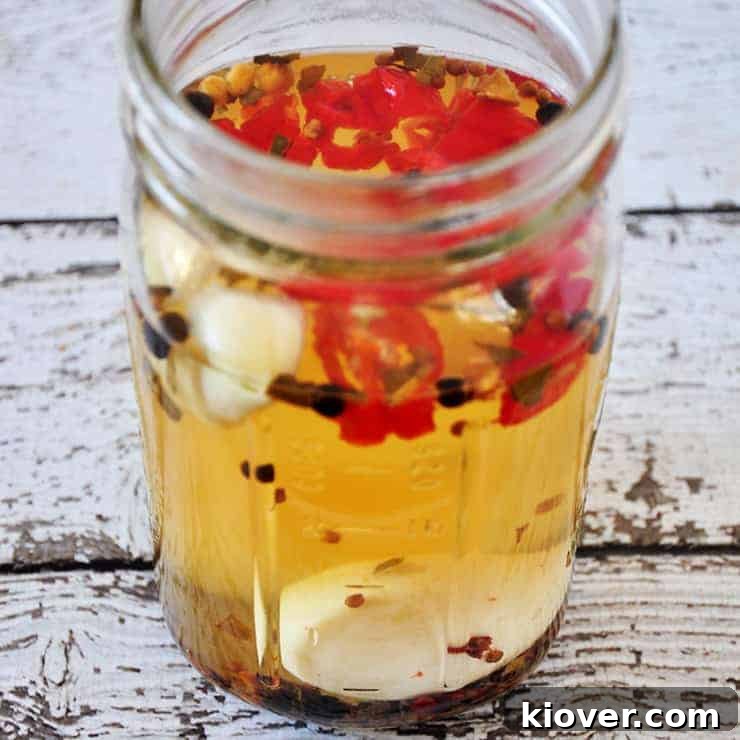 Egg Pickling Hard-boiled eggs submerged in the vibrant pickling brine with peppers and garlic