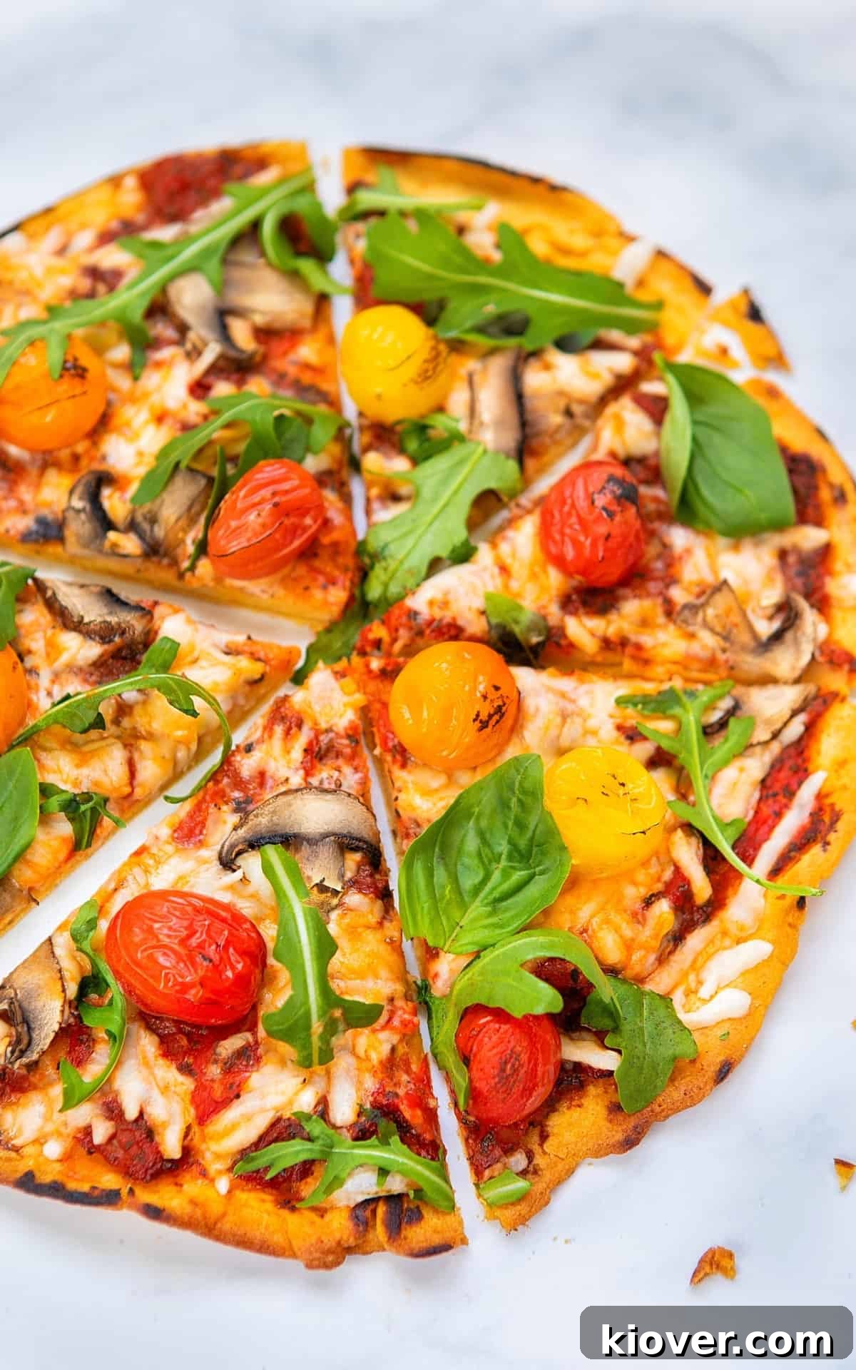 A complete gluten-free pizza with vibrant toppings, artfully placed on a white marble background, ready to be enjoyed.