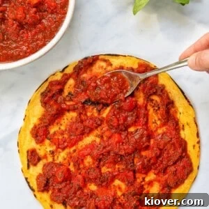Homemade pizza sauce topped on a pizza base, glistening and ready for toppings.
