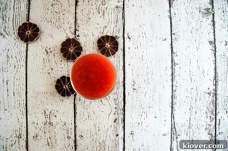 An overhead shot of vibrant homemade tomato juice, showcasing its rich color and inviting texture.