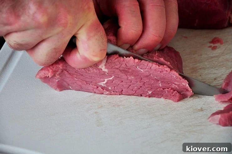 Cutting Jerky Cutting eye of round roast before marinating.
