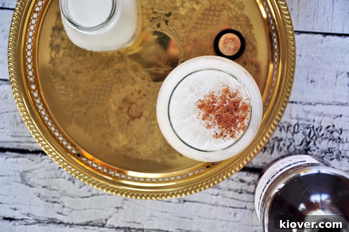 Overhead view of a Milk Punch cocktail in a glass, with grated nutmeg on top