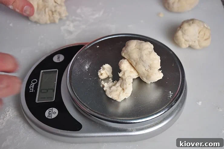Weighing out individual portions of tortilla dough on a kitchen scale, ensuring consistent size.