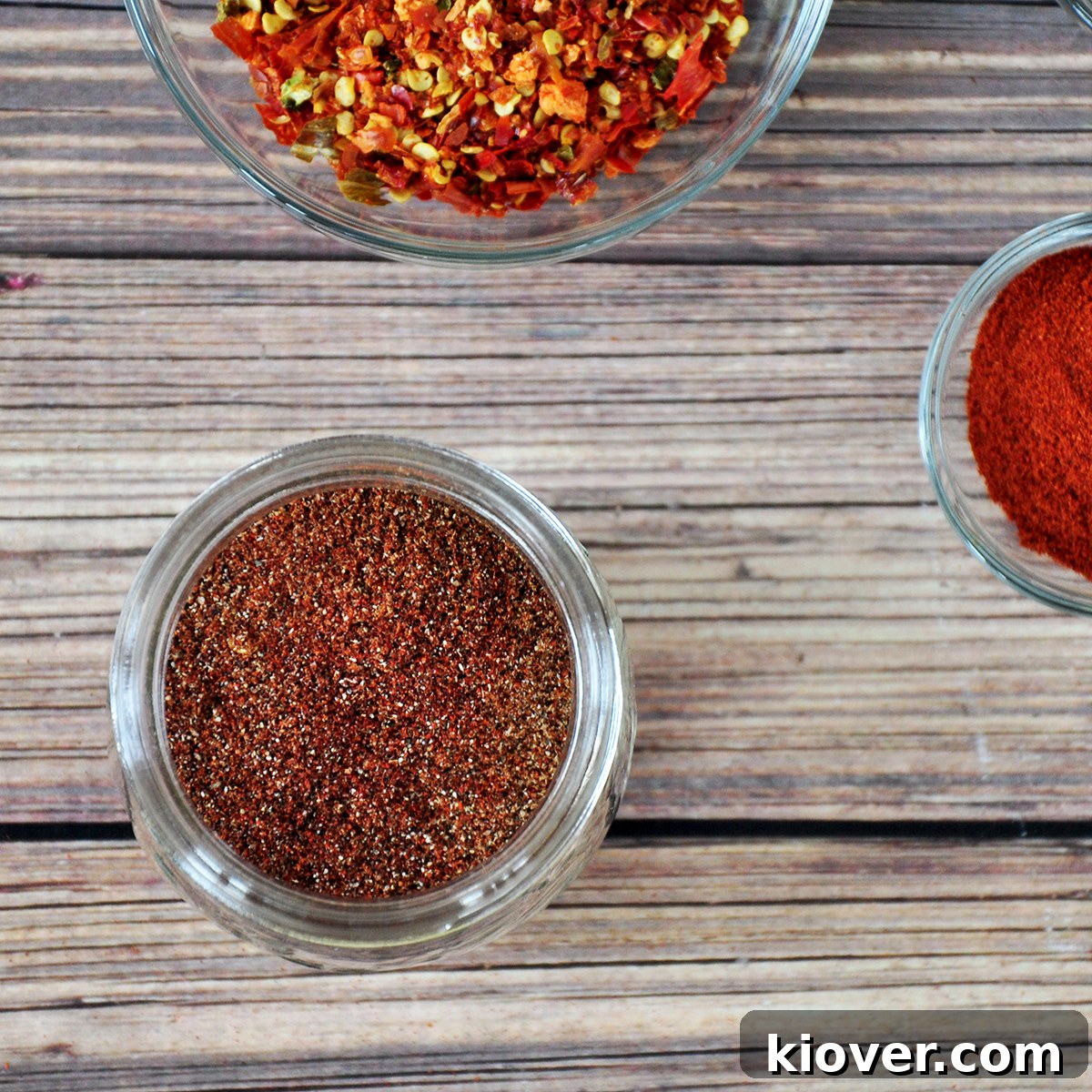 Overhead Homemade Taco Seasoning Overhead picture of homemade taco seasoning mix in a bowl, surrounded by fresh paprika and whole red pepper flakes, showcasing its vibrant color and fresh ingredients.