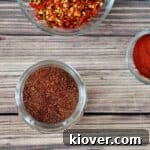 Taco Seasoning in a small mason jar with paprika and crushed peppers off to the side, highlighting the natural ingredients.