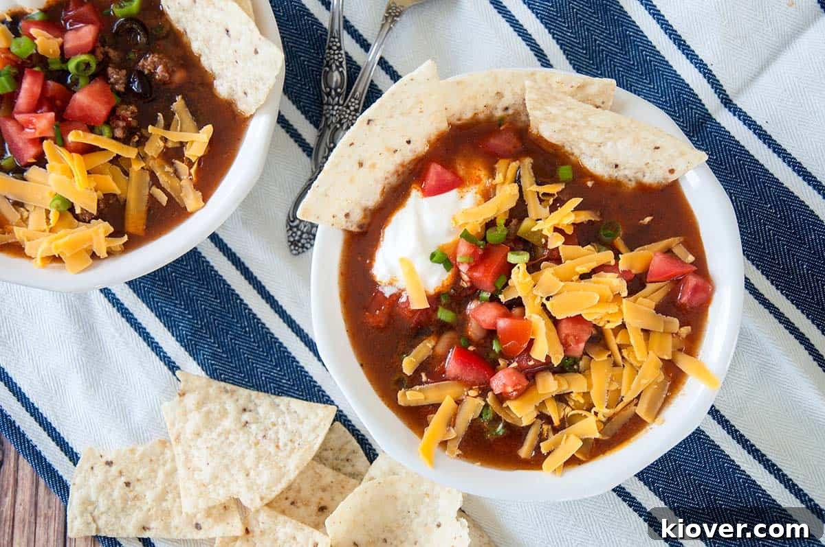 Effortless One-Pot Taco Soup 4 Two bowls of taco soup with cheddar cheese and sour cream on top. A quick and easy dinner solution.
