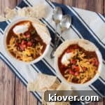 Overhead picture of two bowls of our easy taco soup on a blue and white napkin. Delicious and quick homemade taco soup ready to be served.