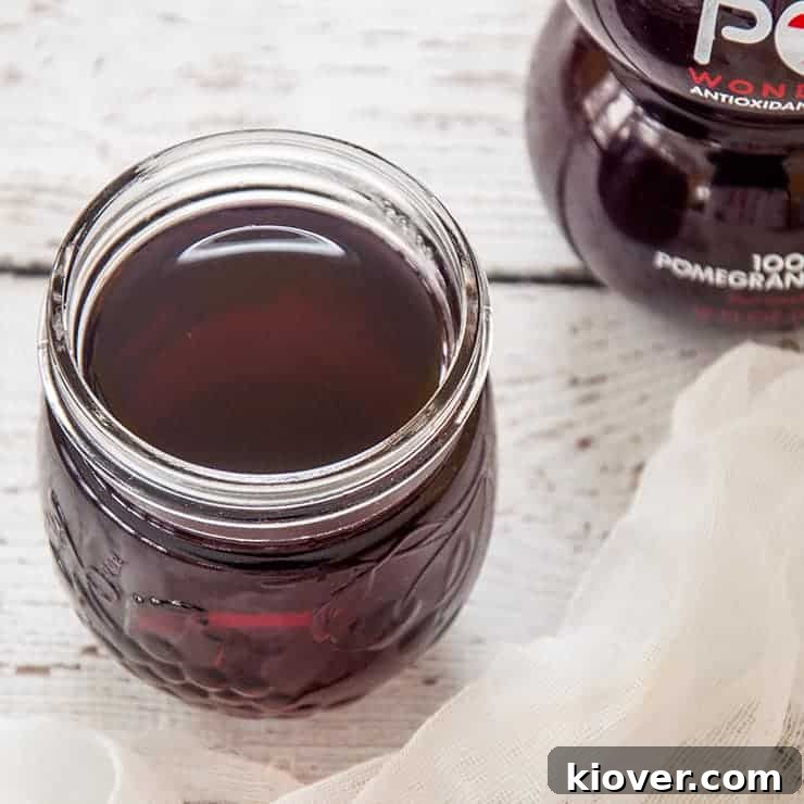 Craft Your Own Grenadine 2 Side view of grenadine in half-pint mason jar and a bottle of Pom in the background.