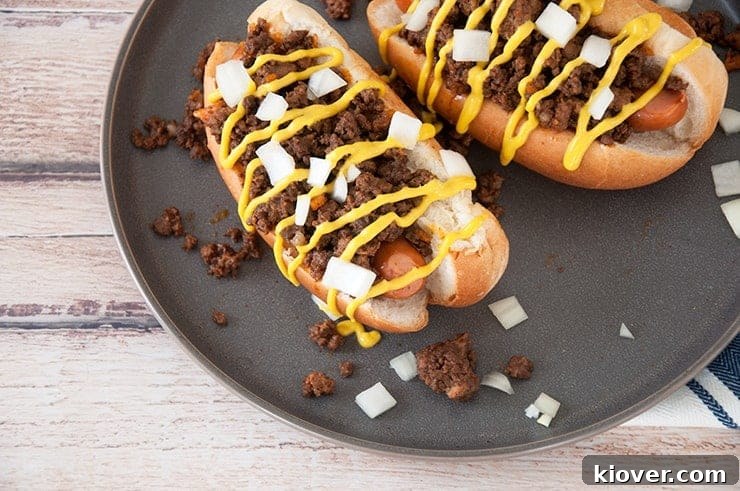 Detroit's Original Coney Dog: Crafted with Homemade Sauce 5 Completed Detroit Coney Dog overhead shot on dark plate and topped with onion and oney