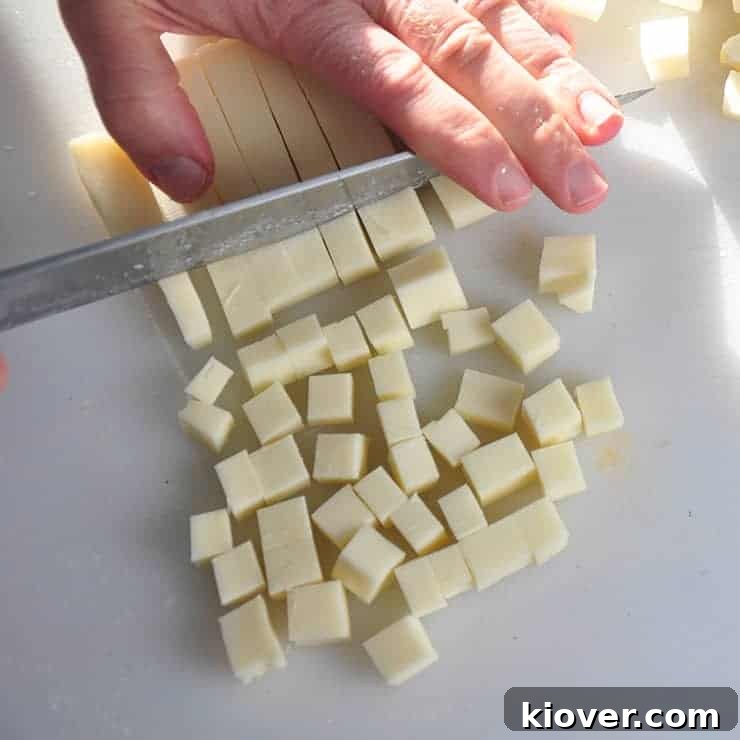 Close-up of Mozzarella Cheese being cut into small, even cubes, ready for the Detroit Style Pizza.