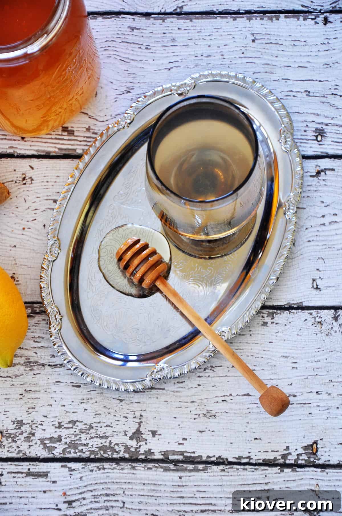 Overhead picture of Homemade Honey Ginger Tea on a silver platter with fresh ginger and honey in the background.