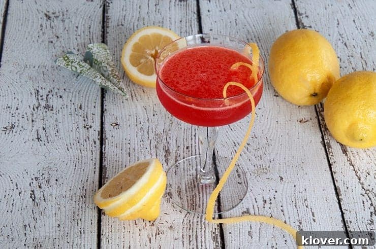Paper Plane Cocktail on a picnic table with three lemons.