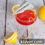 Paper Plane Cocktail with a long lemon twist and lemons in the background