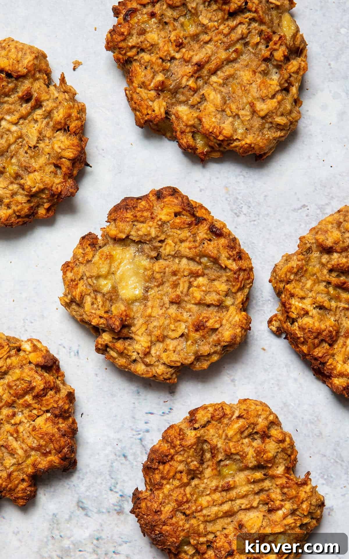 Six perfectly baked oat cookies arranged on a elegant marble background, showcasing their golden brown color and appealing texture.